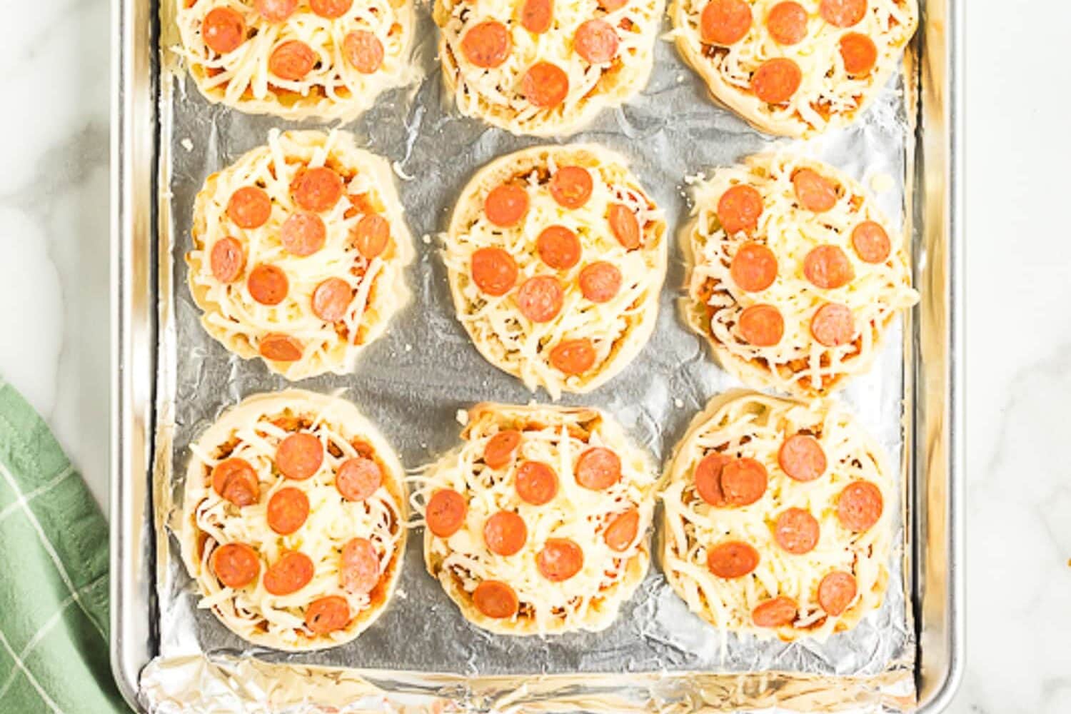 Sheet pan with English Muffin Pizzas before baking
