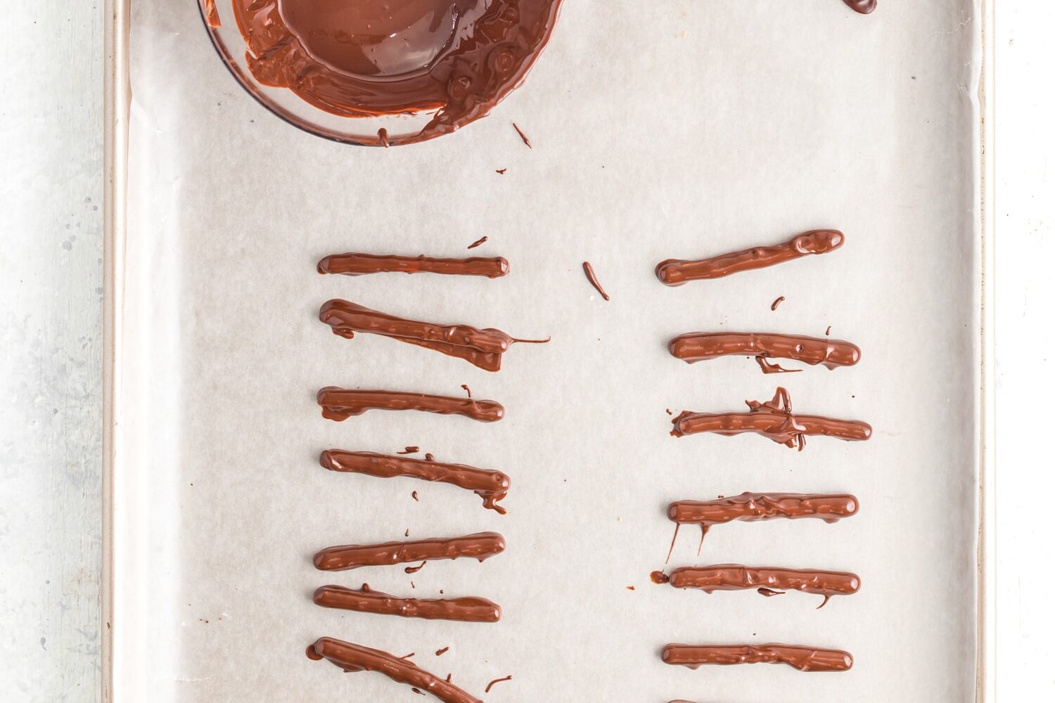 Chocolate dipped pretzel sticks on sheet pan