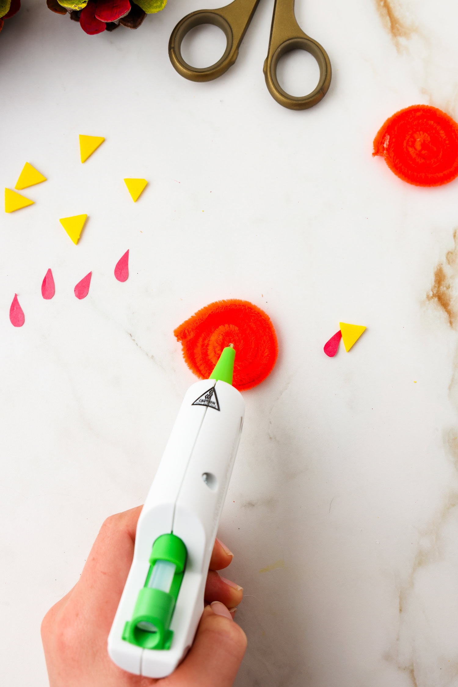 Picture of glue being placed on rolled up pipecleaner for turkey beak.