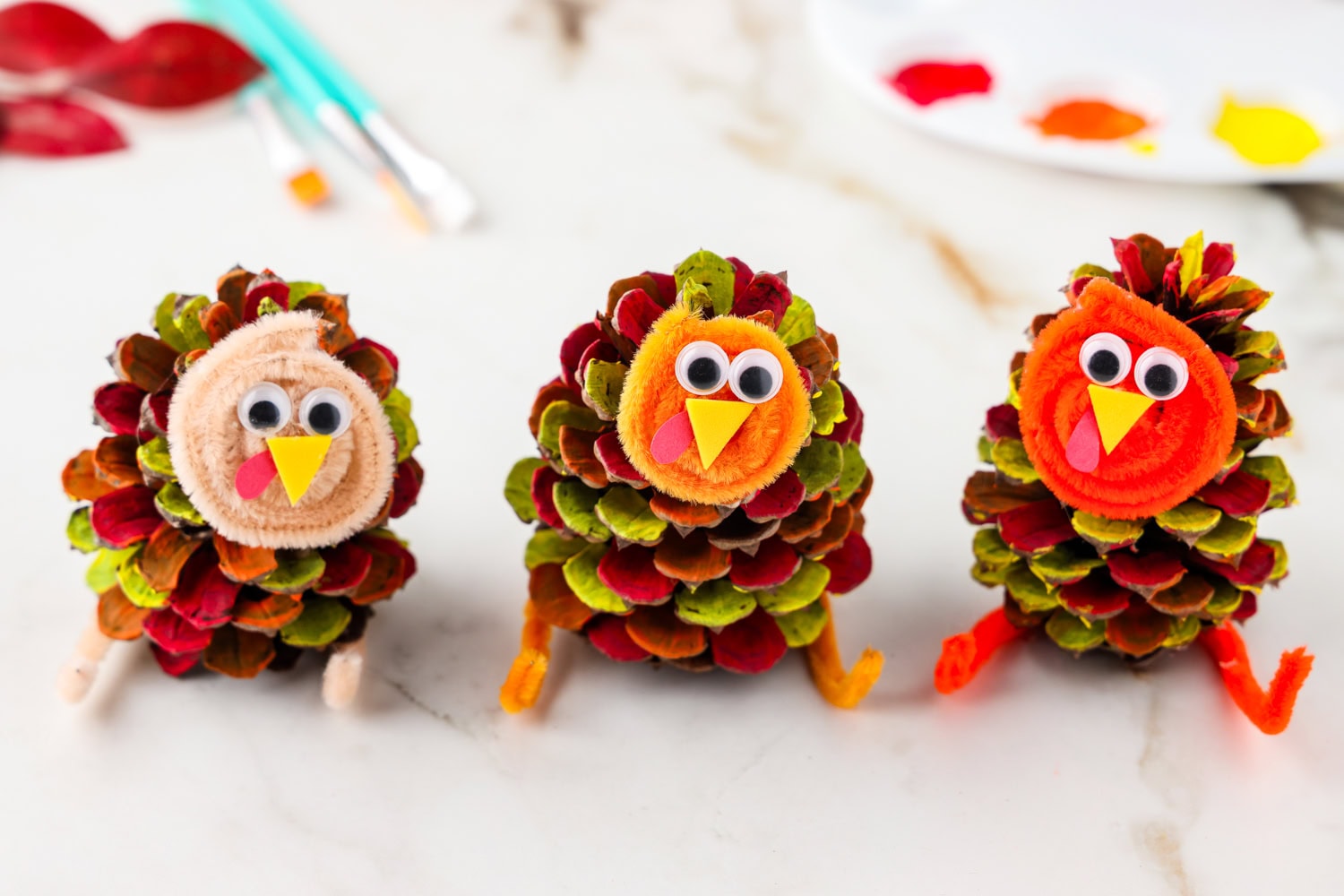 Picture of 3 completed pinecone turkeys sitting next to eachother.