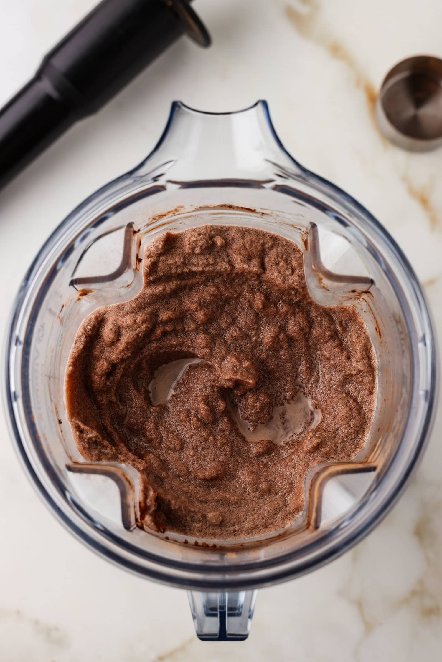 Overhead picture of blended chocolate snow ice cream in a blender.