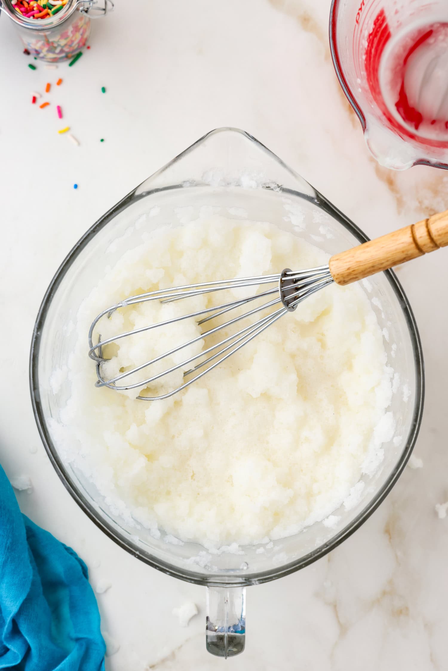 Whisk with snow ice cream ingredients in a glass bowl mixed.