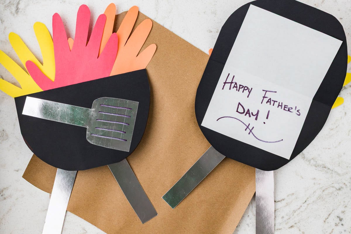 Two finished Father’s Day grill cards displayed open and closed, showing handprint flames and a handwritten message.