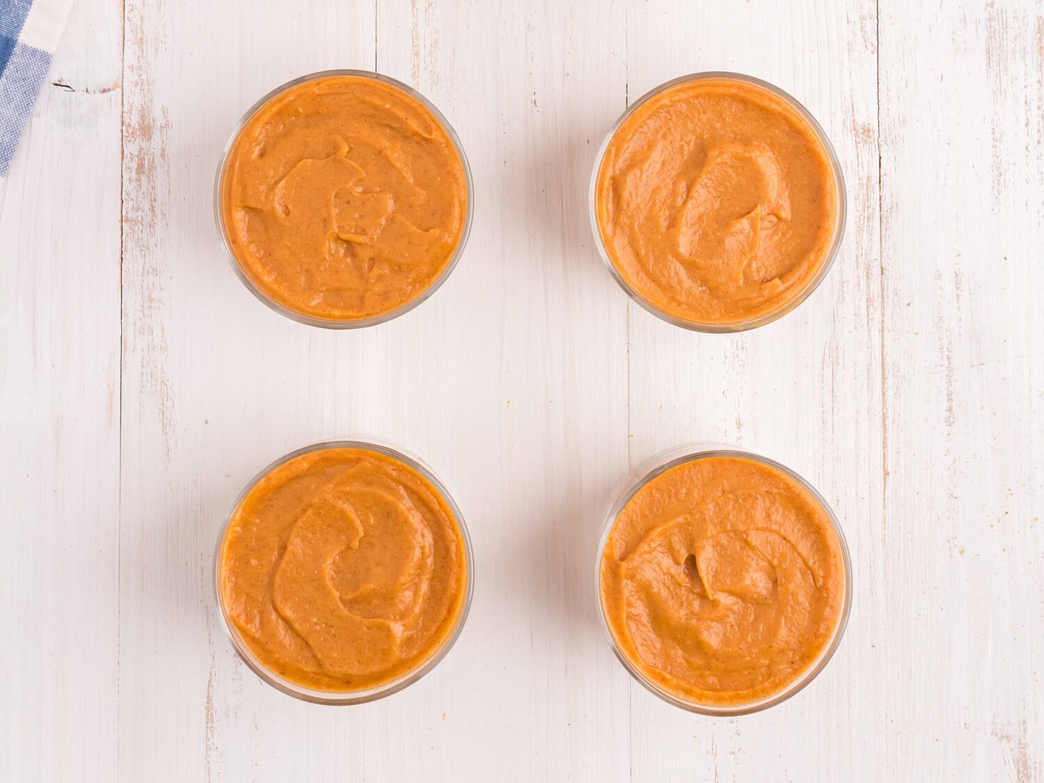 Pumpkin mixture in small cups piped in over graham cracker crust for Pumpkin Pie in a Bag recipe